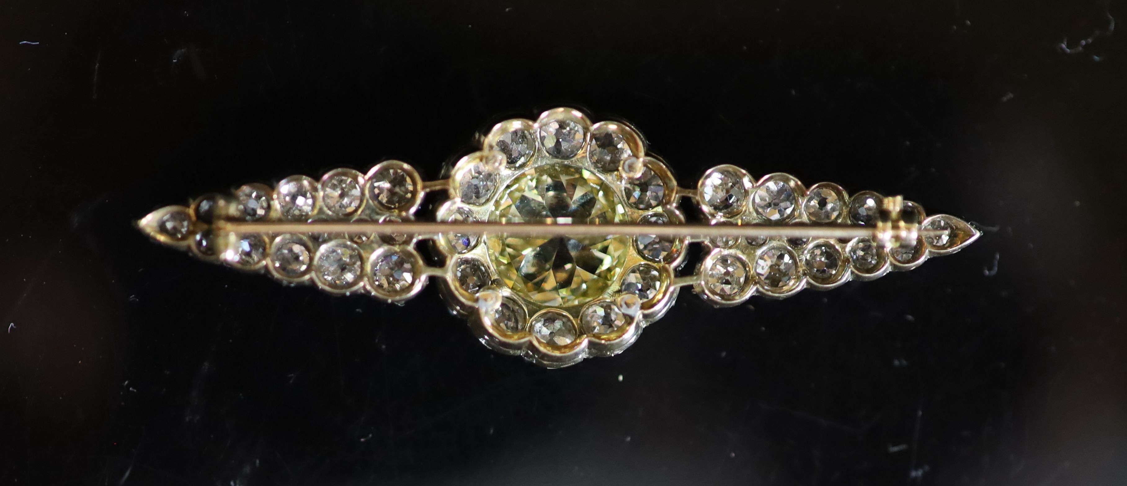 A good early 20th century gold and silver, single stone fancy yellow diamond and old mine cut white diamond set cluster brooch